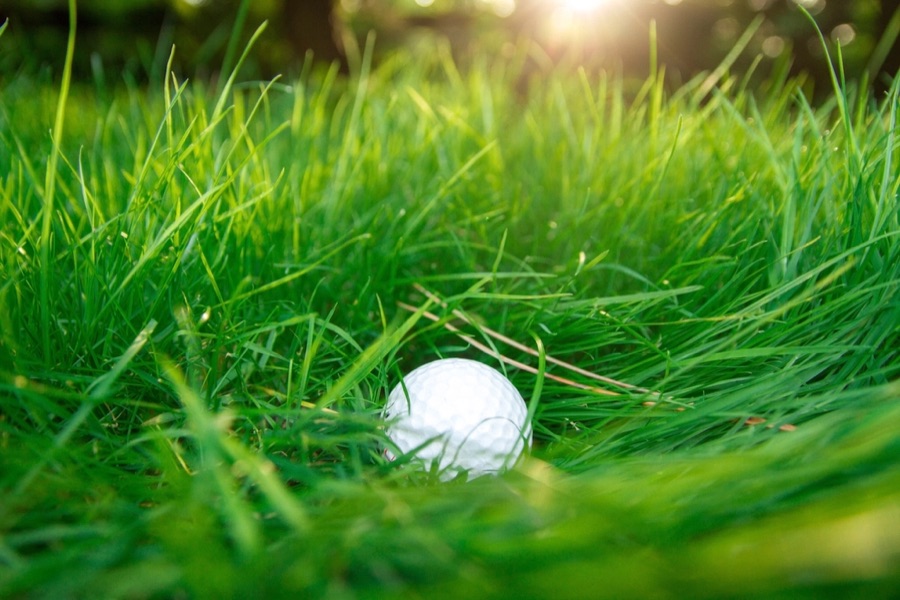 An iron cutting a divot out of the turf just past where the ball was sitting.