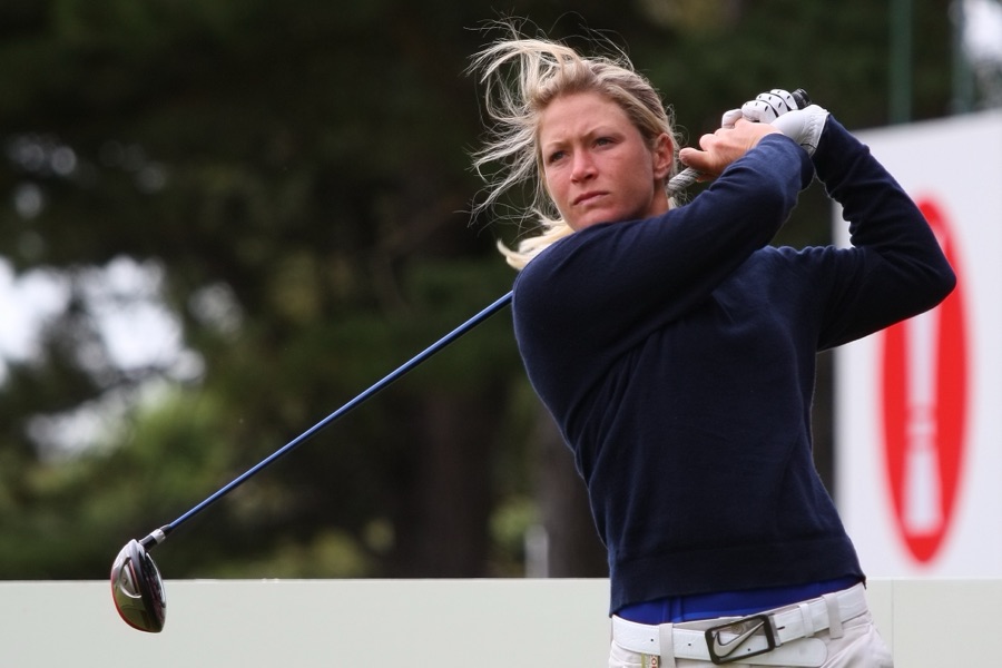 A golfer holding the finish with a driver, upper body and club filling the frame at a tournament.