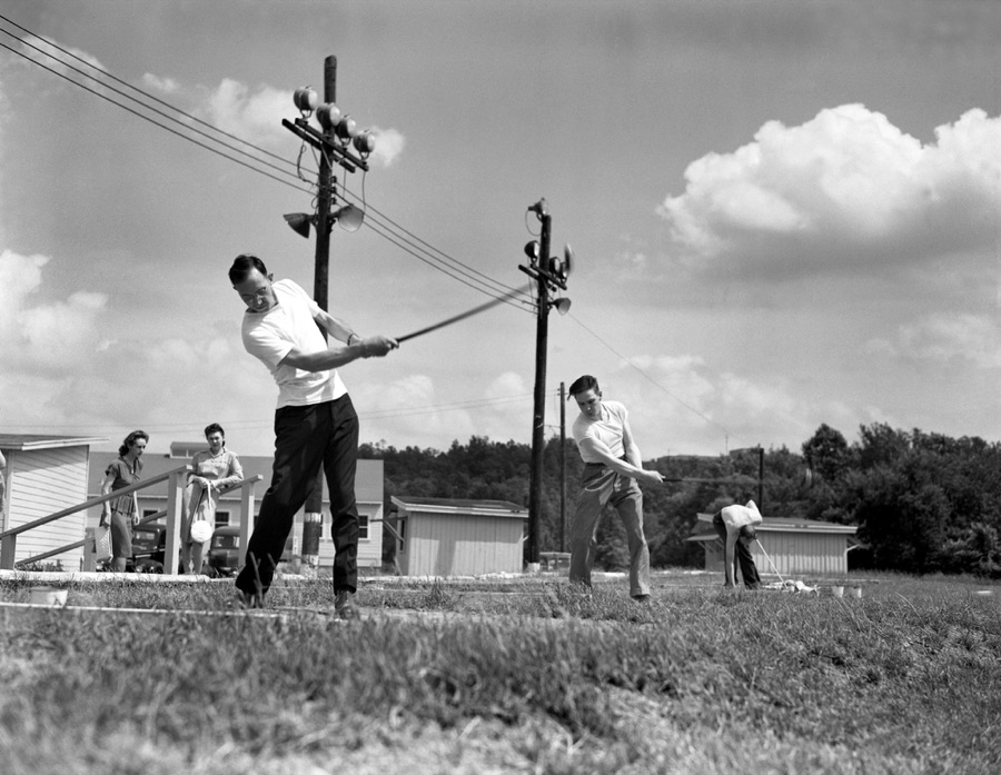 Golfers hitting balls at an outdoor driving range in 1947.