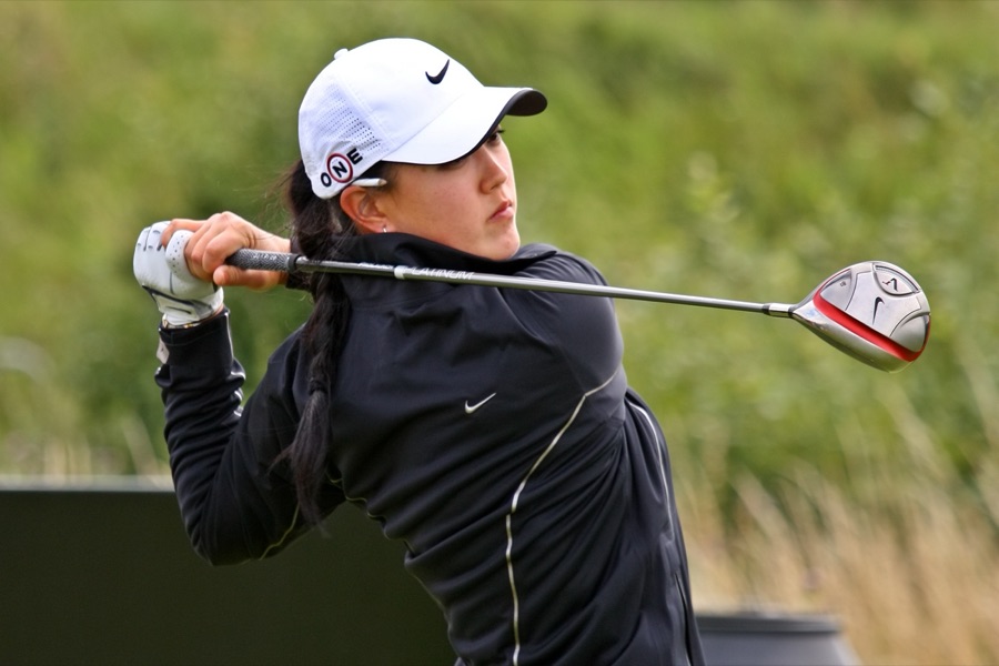 A golfer holding the finish, the driver shaft resting behind the shoulders and both hands still on the grip.