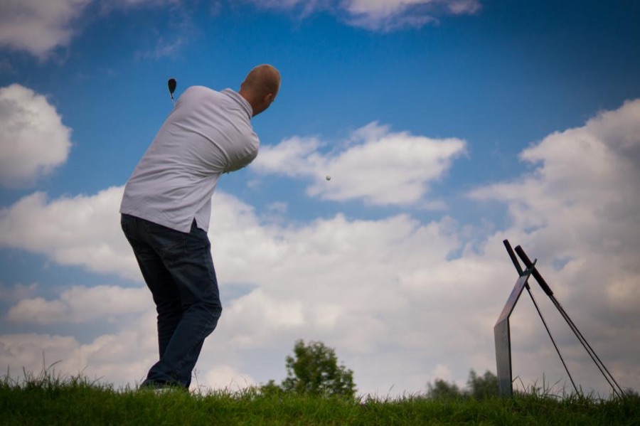 Close-up of a driver clubface meeting the ball at impact, the face still turned slightly open to the direction the clubhead is travelling.